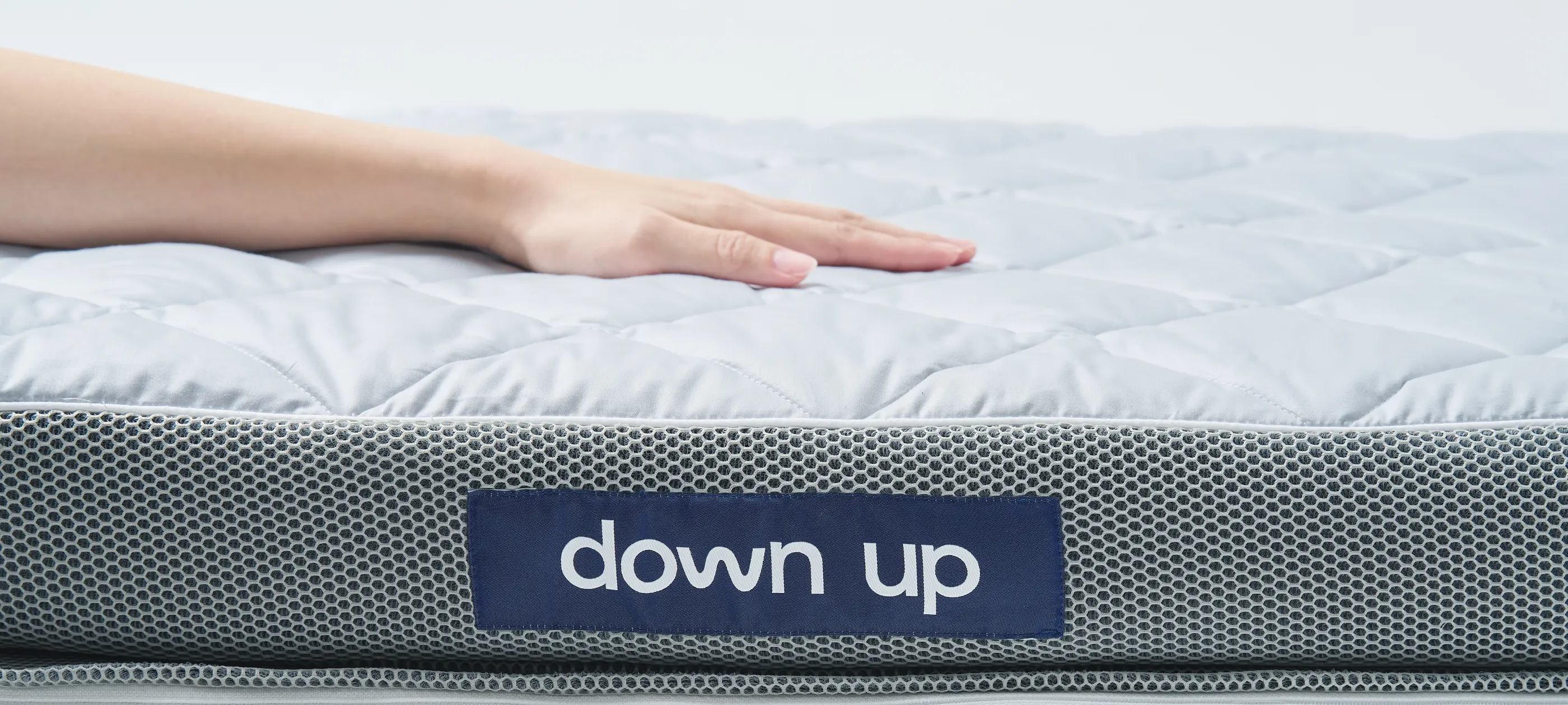 down up のマットレスに手を置いた様子