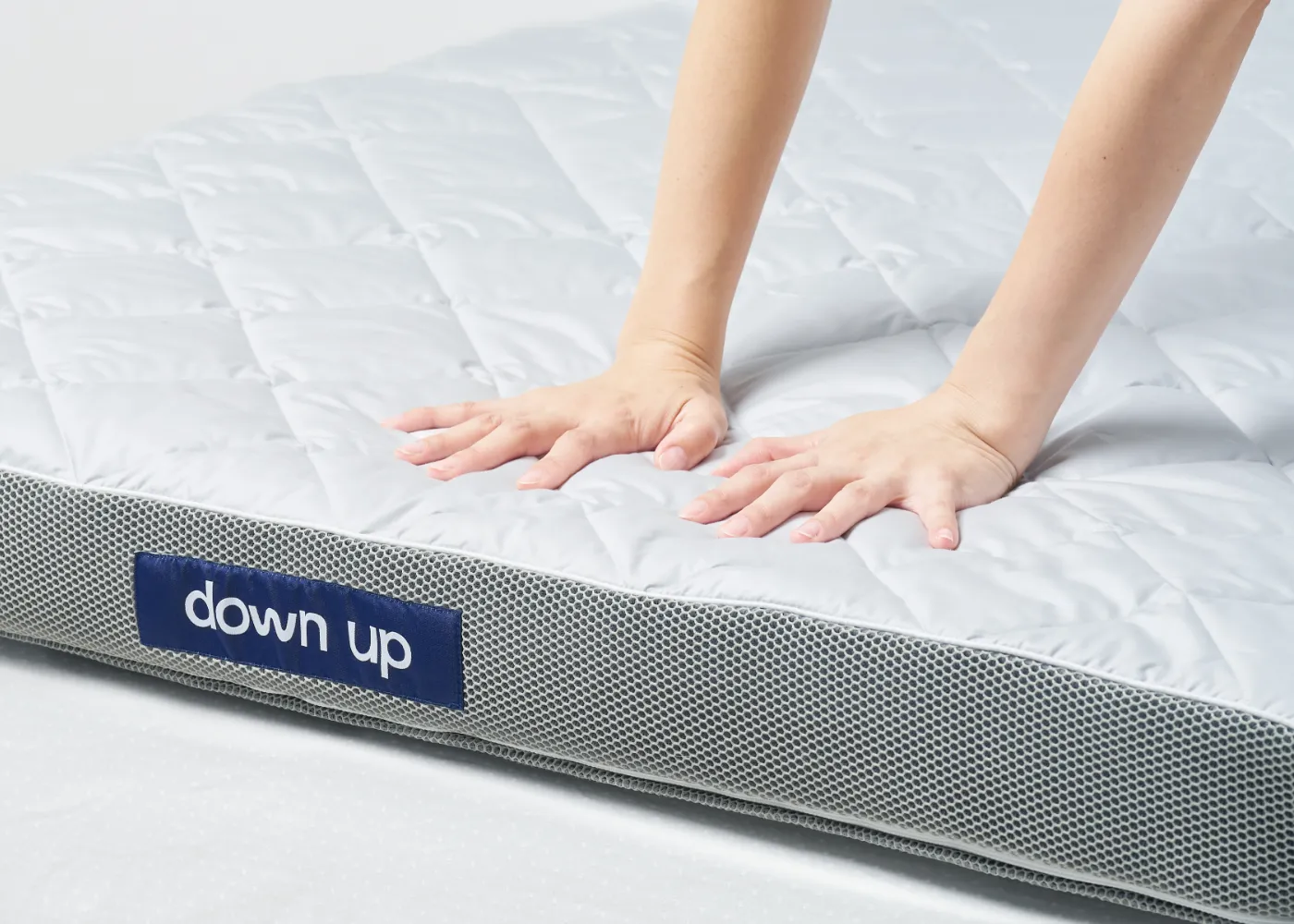 down up のマットレスを手で押した様子